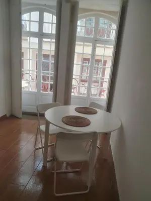 a white table and chairs in a room with windows at Ribeira São Nicolau 1 in Porto