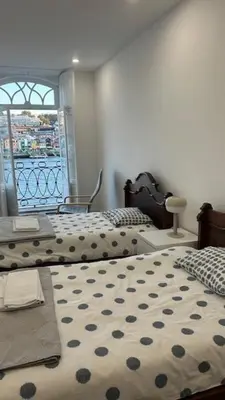 a bedroom with two beds and a window at Ribeira São Nicolau 1 in Porto