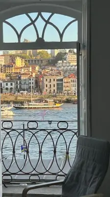 a view of the water from a balcony with a window at Ribeira São Nicolau 1 in Porto