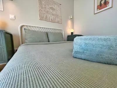 a bedroom with a large bed with a blue blanket at Sunny rooftop duplex with elevator near iconic bridge in Vila Nova de Gaia