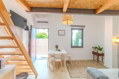 a kitchen and living room with a table and a staircase at VIVA Fontainhas Houses in Porto