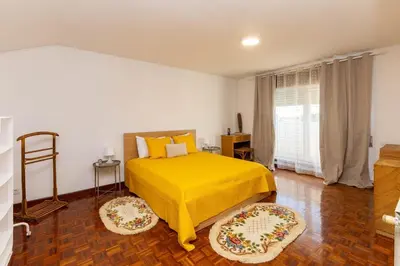a bedroom with a yellow bed and a window at Home Sweet Home in Porto