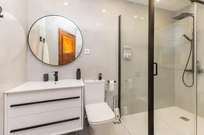 a bathroom with a toilet and a sink and a mirror at Home Sweet Home in Porto