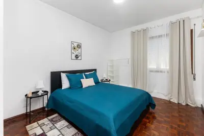 a bedroom with a blue bed and a window at Home Sweet Home in Porto