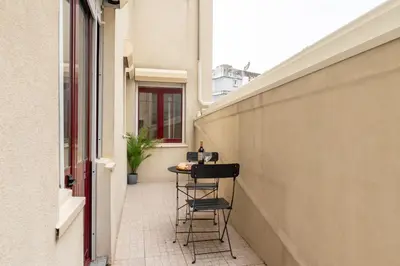 a small balcony with a table and two stools at Modern & Cozy Flat with Workspace by HostWise in Porto