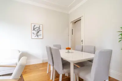 a white dining room with a white table and chairs at Modern & Cozy Flat with Workspace by HostWise in Porto