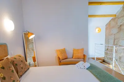 a bedroom with a bed and a chair in a room at VIVA Boavista Duplex Retreat in Porto
