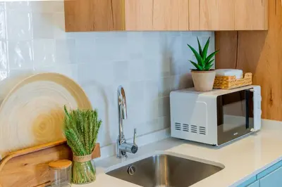a kitchen counter with a sink and a microwave at VIVA Boavista Duplex Retreat in Porto