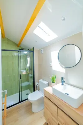 a bathroom with a toilet and a sink and a mirror at VIVA Boavista Duplex Retreat in Porto