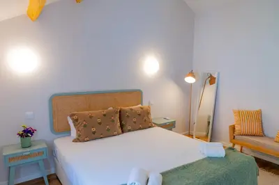 a bedroom with a white bed and a chair at VIVA Boavista Duplex Retreat in Porto