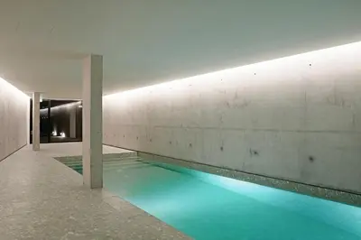 a swimming pool with blue water in a building at Land Roots Riverside Apartments in Vila Nova de Gaia