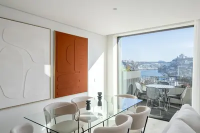 a boat on the river in front of a city at Land Roots Riverside Apartments in Vila Nova de Gaia