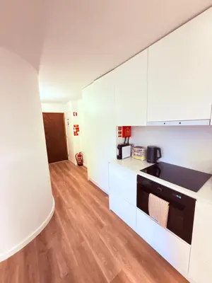a kitchen with white cabinets and a stove top oven at Esmeralda Porto in Porto