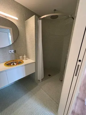 a bathroom with a shower and a sink and a mirror at Esmeralda Porto in Porto