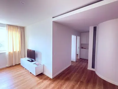 a living room with a television on a white cabinet at Esmeralda Porto in Porto