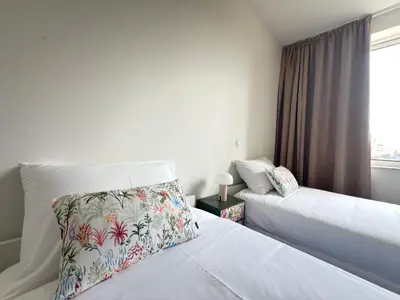 a hotel room with two beds and a window at Esmeralda Porto in Porto