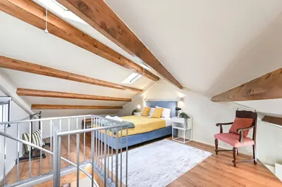 a loft bedroom with a bed and a staircase at Cosy HouseTypical Space in Porto by Su e Luís in Porto