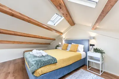 a bedroom with a bed in a room with wooden ceilings at Cosy HouseTypical Space in Porto by Su e Luís in Porto