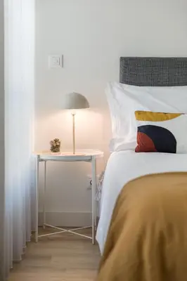 a bedroom with a bed and a table with a lamp at Antas Park with pool and gym - to work & leisure in Porto