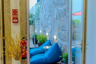 a patio with blue pillows and a table at VIVA República Serviced Apartment in Porto