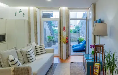 a living room with a white couch and glass doors at VIVA República Serviced Apartment in Porto