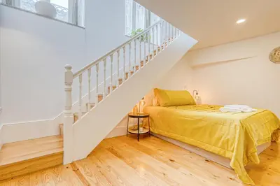 a bedroom with a bed and a staircase at OPORTO GUEST São Brás 66 in Porto