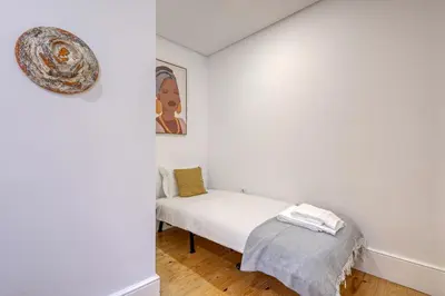a white room with a bed and a picture on the wall at OPORTO GUEST São Brás 66 in Porto