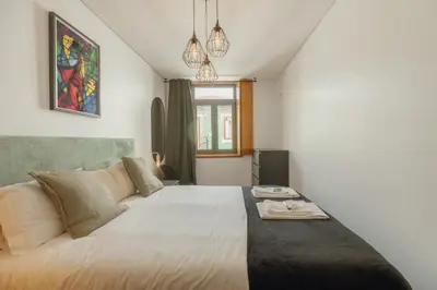 a bedroom with a large bed with a table on it at Modern Terrace 2BD Apartment by Vacationy in Porto