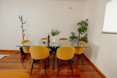 a dining room with a glass table and yellow chairs at Modern Terrace 2BD Apartment by Vacationy in Porto
