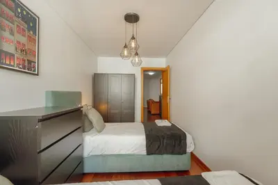 a bedroom with a bed and a desk in it at Modern Terrace 2BD Apartment by Vacationy in Porto