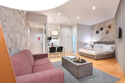 a living room with a couch and a bed at ON Apartments - Free Parking & Pet Friendly in Porto