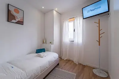 a bedroom with a bed and a tv on the wall at Oporto Nura House Duplex Downtown in Porto