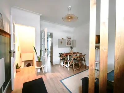 a kitchen with white cabinets and a table and chairs at Casa da Lapa Porto in Porto