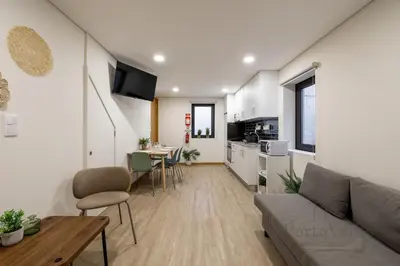 a gray building with two windows and a door at Gloria in Porto - Porto Velho Apt in Porto