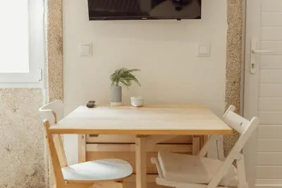 a wooden table and chairs with a potted plant on it at Downtown Cosy Apartment by Vacationy in Porto