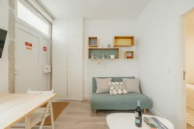 a living room with a green couch and a table at Downtown Cosy Apartment by Vacationy in Porto