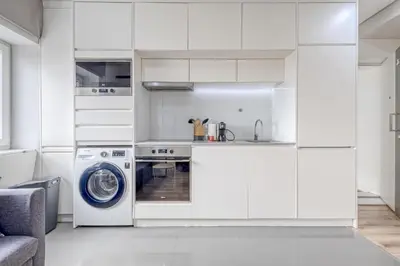 a kitchen with white cabinets and a washing machine at Oporto Guest Green Flat in Porto