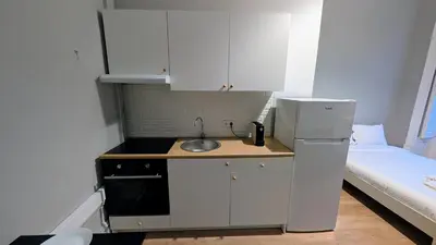 a small kitchen with a sink next to a bed at Riko Guest House 2 in Porto