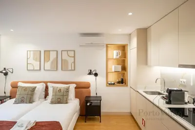 two beds in a small room with a kitchen at Nicos Garden Apartment - Porto Velho Apt in Porto