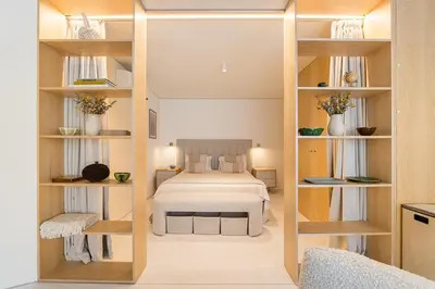 a bedroom with a bed in a room with shelves at DPV Residences - Studio CA/C1 in Porto