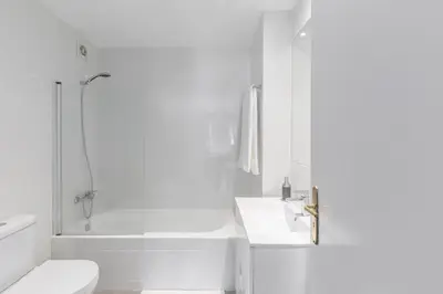 a white bathroom with a toilet and a sink at Vilar 210 in Porto