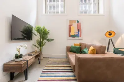 a living room with a brown couch and a tv at Design loft, Downtown Porto in Porto