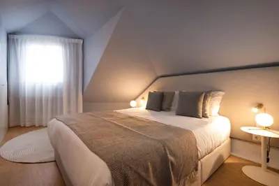 a bedroom with a large bed and a window at Ribeira Apartments Flores in Porto