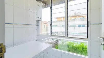 a white bathroom with a window and a bath tub at Charmy Rodrigues Lobo Apartments in Porto