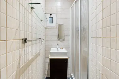 a bathroom with a sink and white tiled walls at GuestReady - Relaxing Place with Terrace in Porto