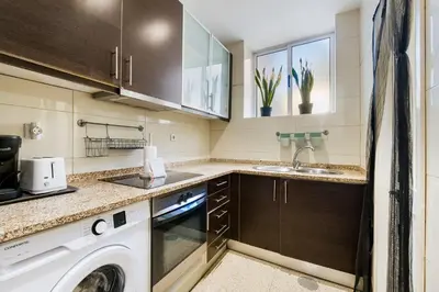 a small kitchen with a washer and dryer at GuestReady - Relaxing Place with Terrace in Porto