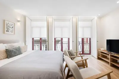 two beds with white sheets and a blue pillow at Studio Glow | 111 Collection in Porto
