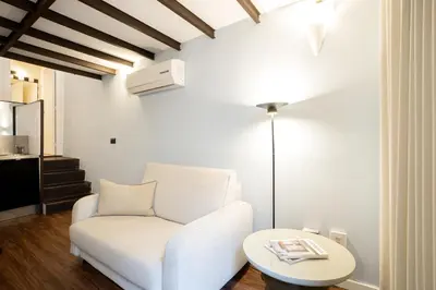 a living room with a white chair and a table at Fine Arts Ateliers by Olala Homes in Porto