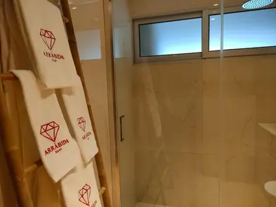 a bathroom with a shower and a towel with diamonds on it at Arrábida Ruby Apartment in Vila Nova de Gaia