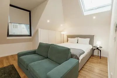 a bedroom with a bed and a couch and a window at Rooftop Constituicao by Vacationy in Porto
